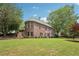 Brick house features a landscaped backyard with mature trees creating an inviting and private outdoor space at 3235 Munsey Ct, Cumming, GA 30041