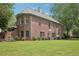 Landscaped backyard with mature trees, showcasing a brick home with an inviting and well-maintained outdoor space at 3235 Munsey Ct, Cumming, GA 30041