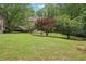 A large backyard featuring a well-maintained lawn, mature trees, and iron fence at 3235 Munsey Ct, Cumming, GA 30041