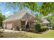 Rear view of a brick home with a covered porch and well-manicured lawn at 3235 Munsey Ct, Cumming, GA 30041