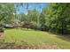 Large backyard featuring mature trees, lush greenery, and space for outdoor recreation, creating a serene environment at 3235 Munsey Ct, Cumming, GA 30041