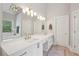 A bright bathroom featuring double sinks, shower, soaking tub, tile floors, and a modern light fixture at 3235 Munsey Ct, Cumming, GA 30041