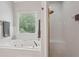 Bright bathroom featuring a soaking tub, walk-in shower, and a window view at 3235 Munsey Ct, Cumming, GA 30041