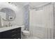 Stylish bathroom featuring a round mirror, marble vanity, and a shower with a white curtain at 3235 Munsey Ct, Cumming, GA 30041