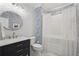 Stylish bathroom featuring blue wallpaper, round mirror and shower with white tile at 3235 Munsey Ct, Cumming, GA 30041