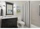 Stylish bathroom with a vanity, black framed mirror, decorative lights, and a shower with a gray shower curtain at 3235 Munsey Ct, Cumming, GA 30041