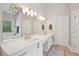 Bright bathroom with double vanity, soaking tub, walk-in shower, and modern light fixture at 3235 Munsey Ct, Cumming, GA 30041
