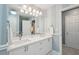 Elegant bathroom featuring double sinks, a large mirror, and striped walls at 3235 Munsey Ct, Cumming, GA 30041