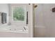 Bright bathroom featuring a jetted tub, window with blinds, and glass-enclosed shower stall at 3235 Munsey Ct, Cumming, GA 30041
