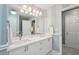 Clean and elegant bathroom with double vanity, large mirror, and blue and white striped walls at 3235 Munsey Ct, Cumming, GA 30041