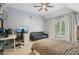 Attic bedroom featuring windows, ceiling fan, desk area, lounge area, and unique headboard at 3235 Munsey Ct, Cumming, GA 30041