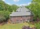 Rear exterior featuring well-maintained landscaping and a brick facade, complemented by lush green lawn at 3235 Munsey Ct, Cumming, GA 30041