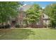 Charming brick home with lush green lawn and mature trees in a desirable neighborhood at 3235 Munsey Ct, Cumming, GA 30041
