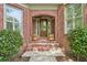 Charming brick front entrance with a decorative door and potted plants at 3235 Munsey Ct, Cumming, GA 30041