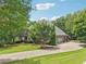 Beautiful brick home featuring an expansive driveway, attached garage, mature trees, and manicured landscaping at 3235 Munsey Ct, Cumming, GA 30041