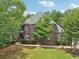 Brick home featuring manicured front lawn, mature trees, and a welcoming entrance, showcasing its curb appeal at 3235 Munsey Ct, Cumming, GA 30041