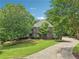 Charming brick home featuring a manicured lawn, mature trees and a winding driveway at 3235 Munsey Ct, Cumming, GA 30041