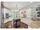 Bright kitchen features white cabinets, stainless steel appliances, and a center island with granite countertop at 3235 Munsey Ct, Cumming, GA 30041