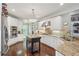 Well-lit kitchen with white cabinets, stainless steel appliances, granite countertops, and dark hardwood flooring at 3235 Munsey Ct, Cumming, GA 30041