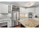 Bright kitchen features stainless steel appliances, wine rack, granite counters, and an island at 3235 Munsey Ct, Cumming, GA 30041