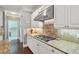 Close-up kitchen view featuring granite countertops, a stainless-steel range hood, and white cabinetry at 3235 Munsey Ct, Cumming, GA 30041