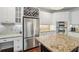 Modern kitchen featuring stainless steel appliances, granite countertops, and white cabinets and an adjacent workstation at 3235 Munsey Ct, Cumming, GA 30041