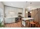 Modern kitchen with stainless appliances, tiled backsplash, center island, and hardwood floors at 3235 Munsey Ct, Cumming, GA 30041