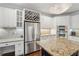 Bright kitchen with stainless steel refrigerator, white cabinetry, a wine rack, and granite countertop island at 3235 Munsey Ct, Cumming, GA 30041