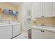 Well-lit laundry room featuring modern washer/dryer, white cabinetry, and a utility sink at 3235 Munsey Ct, Cumming, GA 30041