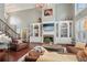 Spacious living room with fireplace, built-in shelves, hardwood floors, and large windows for natural light at 3235 Munsey Ct, Cumming, GA 30041