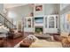 Living room with custom built-ins, fireplace, staircase, and large windows offering plenty of natural light at 3235 Munsey Ct, Cumming, GA 30041