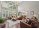 Open floor plan featuring a living room with soaring ceilings, large windows, and comfortable leather seating at 3235 Munsey Ct, Cumming, GA 30041