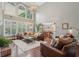 Great room featuring large windows, vaulted ceilings, hardwood floors, fireplace, and custom lighting fixture at 3235 Munsey Ct, Cumming, GA 30041