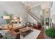 Open living room with hardwood floors, neutral walls, staircase, and large windows providing plenty of light at 3235 Munsey Ct, Cumming, GA 30041