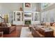 Bright living room with custom built-ins, fireplace, and large windows offering plenty of natural light at 3235 Munsey Ct, Cumming, GA 30041
