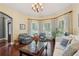 Bright living room features hardwood floors, a bay window with elegant curtains, and comfortable seating at 3235 Munsey Ct, Cumming, GA 30041