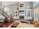Spacious living room featuring a cozy fireplace, built-in bookshelves, and comfortable leather seating at 3235 Munsey Ct, Cumming, GA 30041