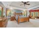 Large primary bedroom with a tray ceiling, hardwood furniture, and window views at 3235 Munsey Ct, Cumming, GA 30041