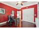 Bright home office with red walls, white trim, hardwood floors, and a double-door closet at 3235 Munsey Ct, Cumming, GA 30041
