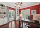 Home office featuring red walls, built-in shelving, hardwood floors, shutters, and french doors at 3235 Munsey Ct, Cumming, GA 30041