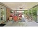 Covered patio with brick accent wall, ceiling fan, TV, and comfortable seating provides relaxing outdoor living at 3235 Munsey Ct, Cumming, GA 30041