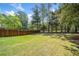 Expansive backyard featuring a lush green lawn and bordered by a wood fence and mature trees at 5247 Hayden Farms Dr, Powder Springs, GA 30127