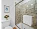 This bathroom's clean lines showcase an updated shower, neutral mosaic tile, and a framed piece of artwork at 5247 Hayden Farms Dr, Powder Springs, GA 30127