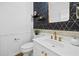 Stylish powder room featuring wainscoting, gold accents, modern fixtures and a geometric wallpaper at 5247 Hayden Farms Dr, Powder Springs, GA 30127