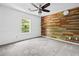 Bedroom featuring a wooden accent wall, ceiling fan, and ample natural light at 5247 Hayden Farms Dr, Powder Springs, GA 30127