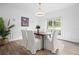Formal dining room featuring wainscoting, modern lighting, and a large window overlooking the backyard at 5247 Hayden Farms Dr, Powder Springs, GA 30127