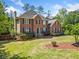 Traditional two-story brick home with black shutters, a landscaped yard, and mature trees at 5247 Hayden Farms Dr, Powder Springs, GA 30127