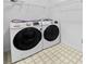 Modern laundry room features side-by-side washer and dryer with overhead wire racks for storage at 5247 Hayden Farms Dr, Powder Springs, GA 30127