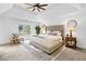 Spacious main bedroom with a tray ceiling, sitting area, and large window overlooking front yard at 5247 Hayden Farms Dr, Powder Springs, GA 30127