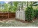 Backyard shed offers practical storage solutions, complemented by landscaping and a privacy fence in the outdoor space at 5247 Hayden Farms Dr, Powder Springs, GA 30127
